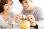 貯金箱にお金を入れる元気な韓国人の妻と夫。