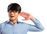 手のジェスチャーをする韓国出身の眼鏡をかけた男性。