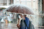 雨の中で傘をさす韓国人男性。