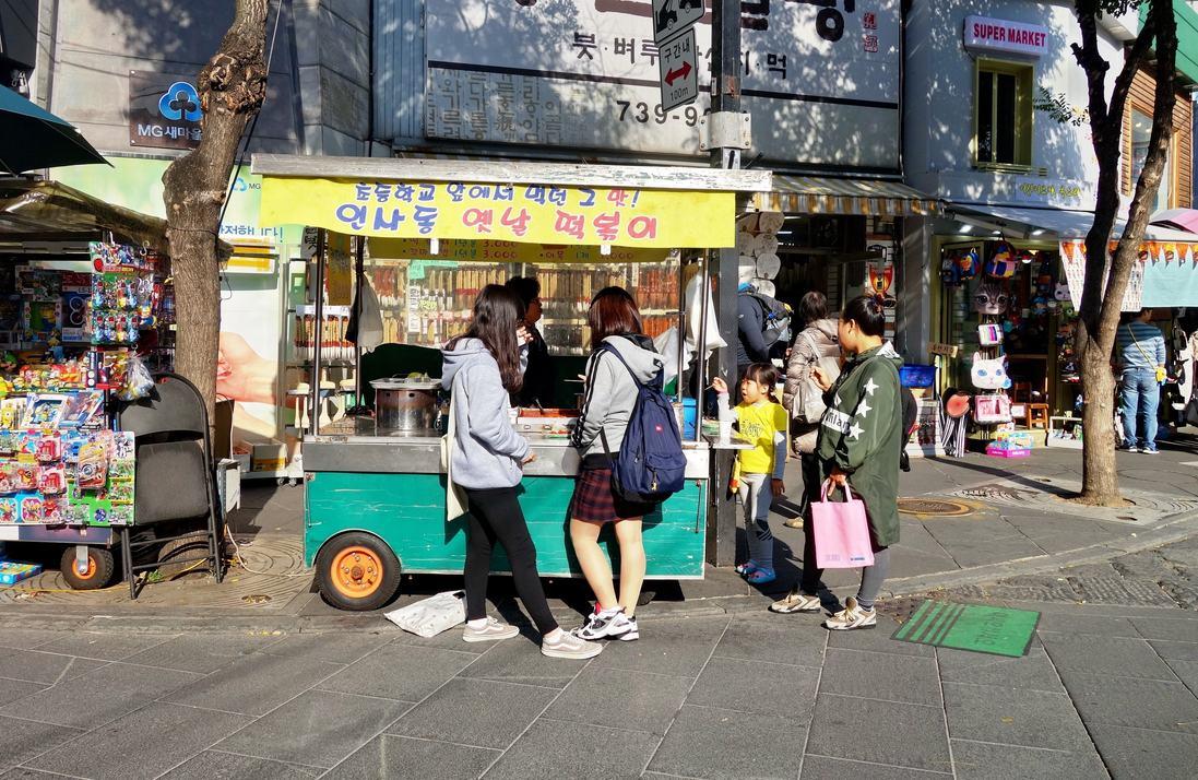 韓国の屋台の前に立つ人々のグループ。