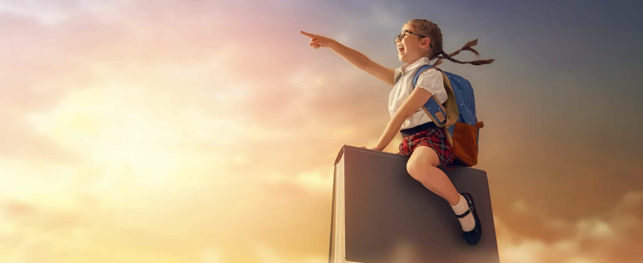 韓国の箱の上に座って空を指差す女の子。