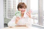 窓の前でお金を持っている韓国人女性。