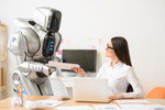 女性が机に座り、目の前にロボットがいて、韓国の最新技術を紹介している。