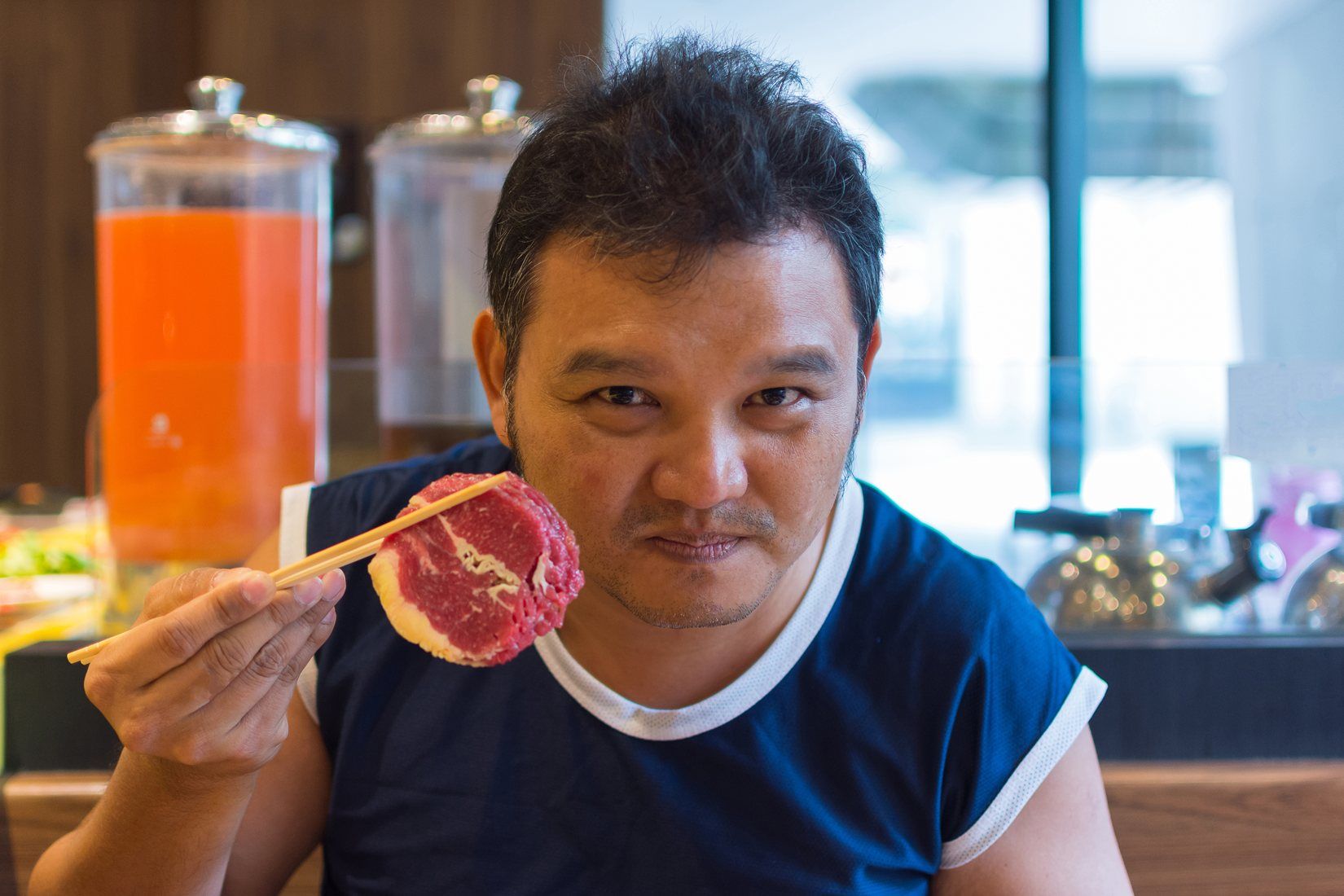 肉を箸で食べる韓国の男性。