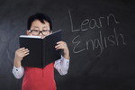 韓国語と書かれた本を持った少年。