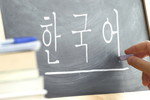 パッチムの練習をしながら黒板に書く韓国語初級者。