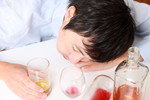 韓国で男性がワインを飲みながらテーブルに横たわっている。