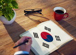 ビジネスマンが韓国の国旗が描かれたノートに書いています。