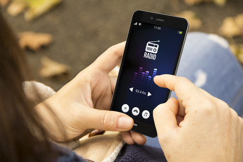 ラジオアプリが入ったスマートフォンを持つ韓国人女性。