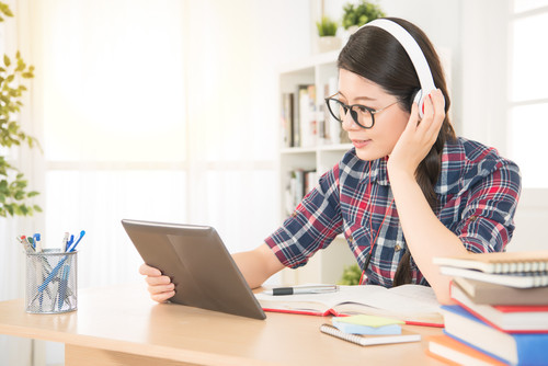 自宅で音楽を聴き、ラップトップを使用している韓国人女性。