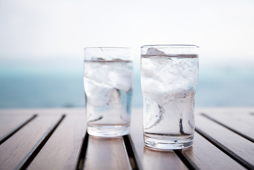 韓国の木製テーブルの上に氷の入った水を2杯。