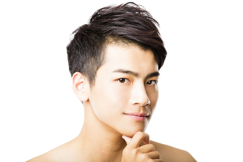 あごに手を当ててポーズをとる韓国出身の若いアジア人男性。