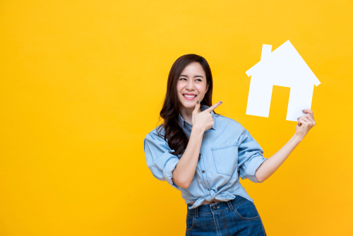 韓国の黄色の背景に家を持つアジアの若い女性。