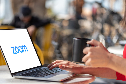 韓国の女性は、Zoom のロゴが入ったラップトップを使用しています。