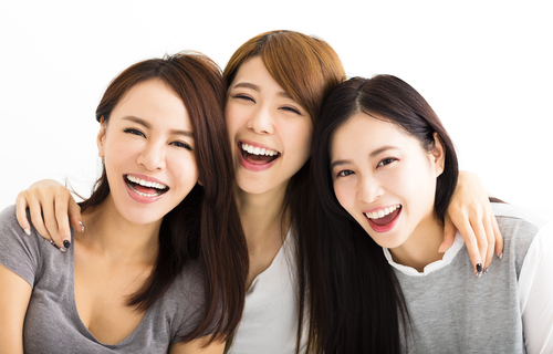 白い背景で一緒に笑う 3 人の韓国人女性。