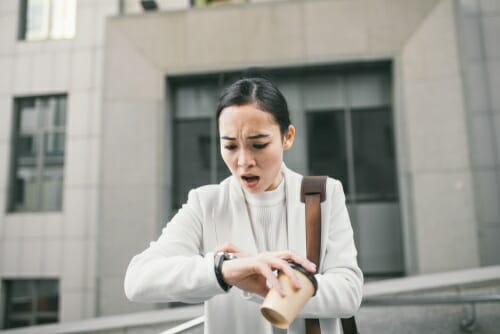 韓国から来た女性が時計を見ながら階段を降りています。