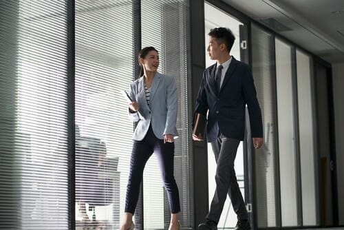 한オフィスを歩く2人のビジネスマン。