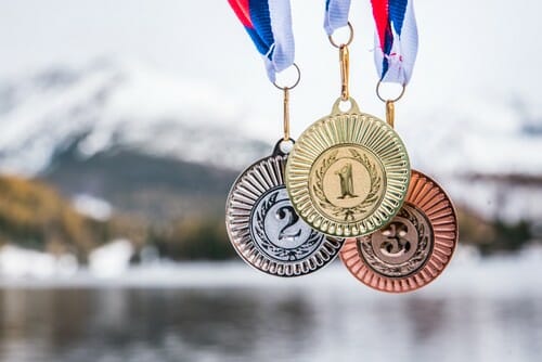 韓国の山を背景に湖の前にぶら下がっている3つのメダル。