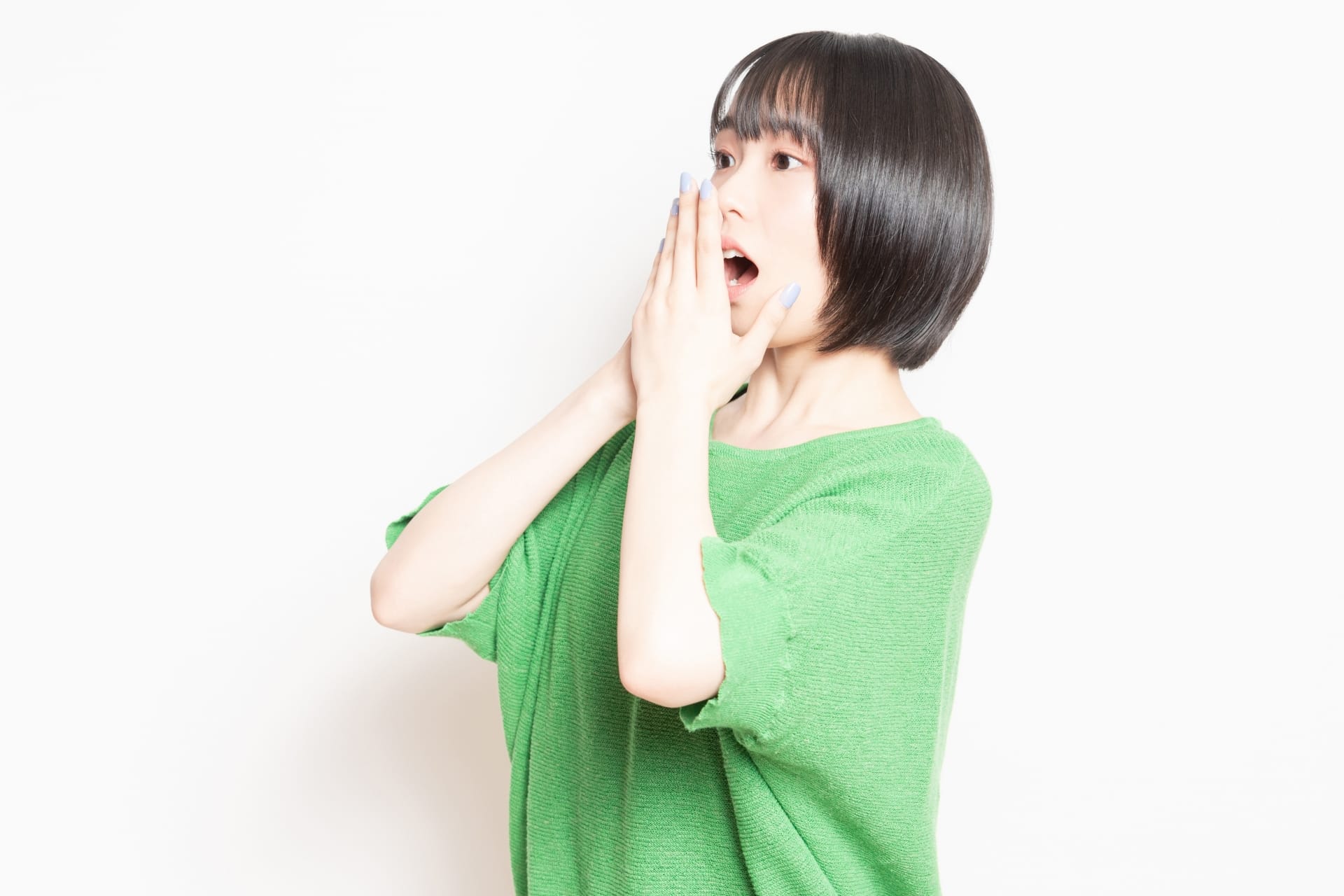 黒い短髪に緑のシャツを着た人物が両手で口を覆い、真っ白な背景を背景に、まるで韓国語で何か面白いことを聞いたばかりのように、本当に驚いた表情を見せている。.