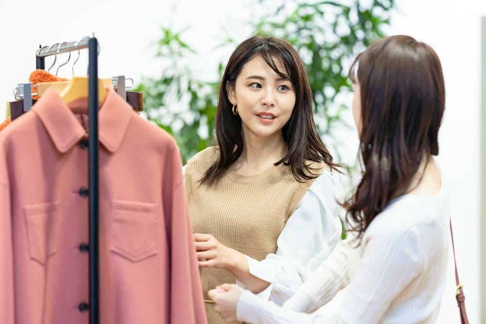 ラックの上の服を見ている 2 人の韓国人女性。