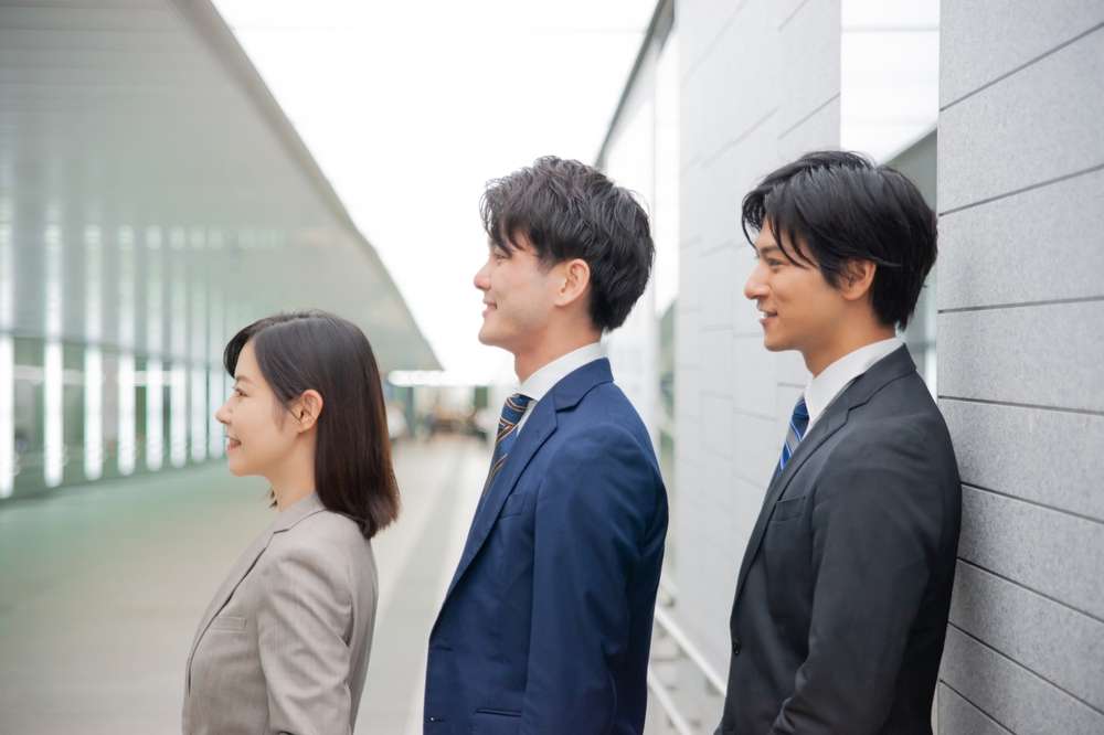 隣り合って立つ韓国人ビジネスマンのグループ。
