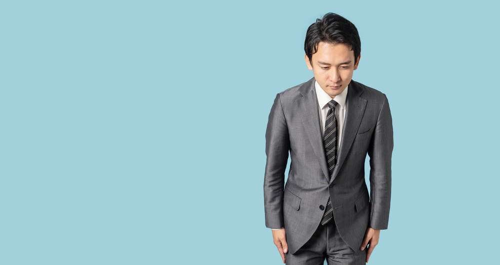 韓国の青い背景に立つスーツを着た男性。