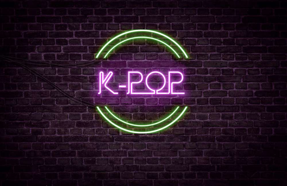 レンガの壁に「韓国 k-pop」と表示されたネオンサイン。