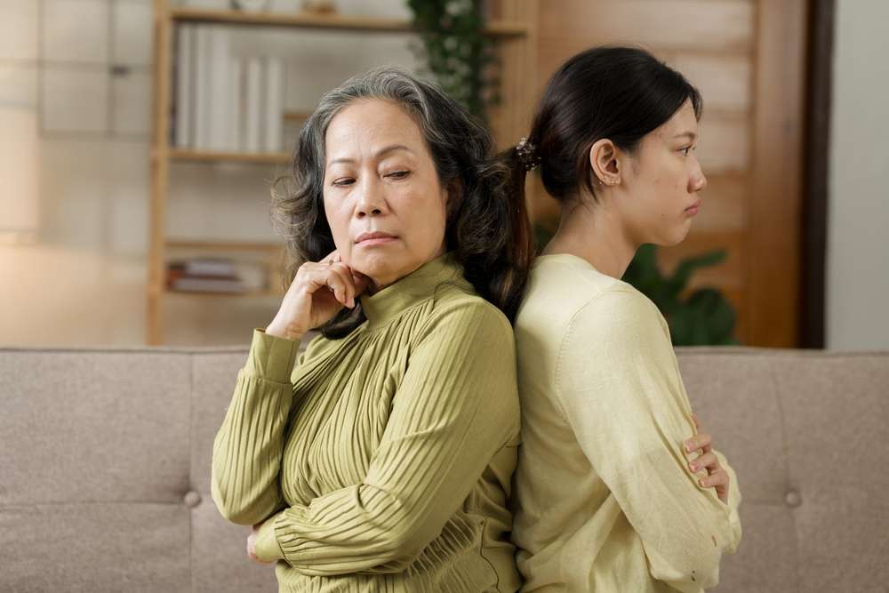 ソファに背中合わせに座っている二人の女性は、どちらも意見が食い違っているように見える。年上の女性は思案しているように見え、若い女性は動揺しているように見える。彼女たちの表情は、韓国ドラマで見られる緊張感を反映している。