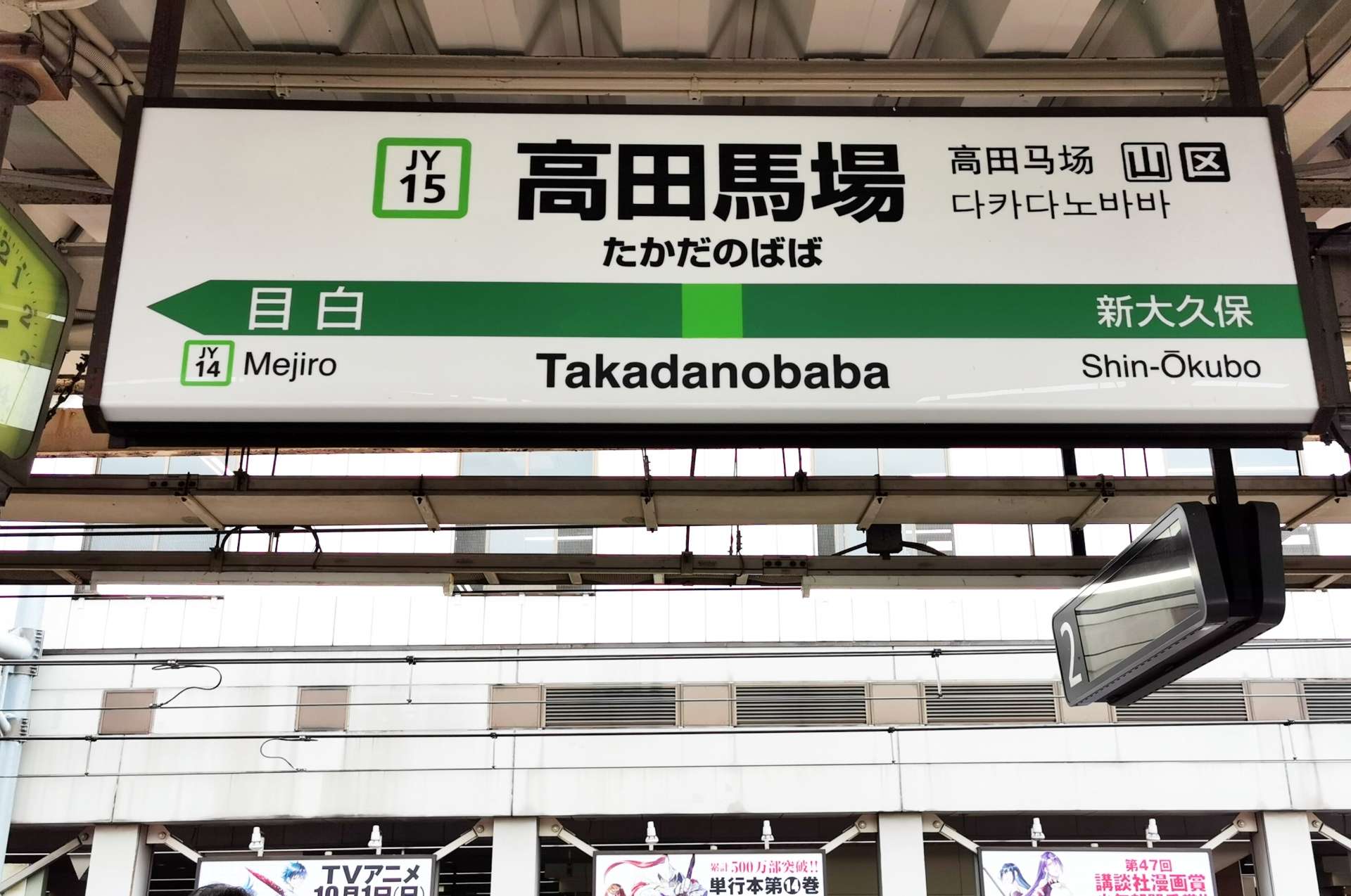 高田馬場の駅名標には、駅番号と隣接する目白駅 (JY14) と新大久保駅 (JY16) が日本語、英語、韓国語で表示されています。近くの韓国語教室では、韓国文化をより深く知りたい人向けに語学レッスンを提供しています。
