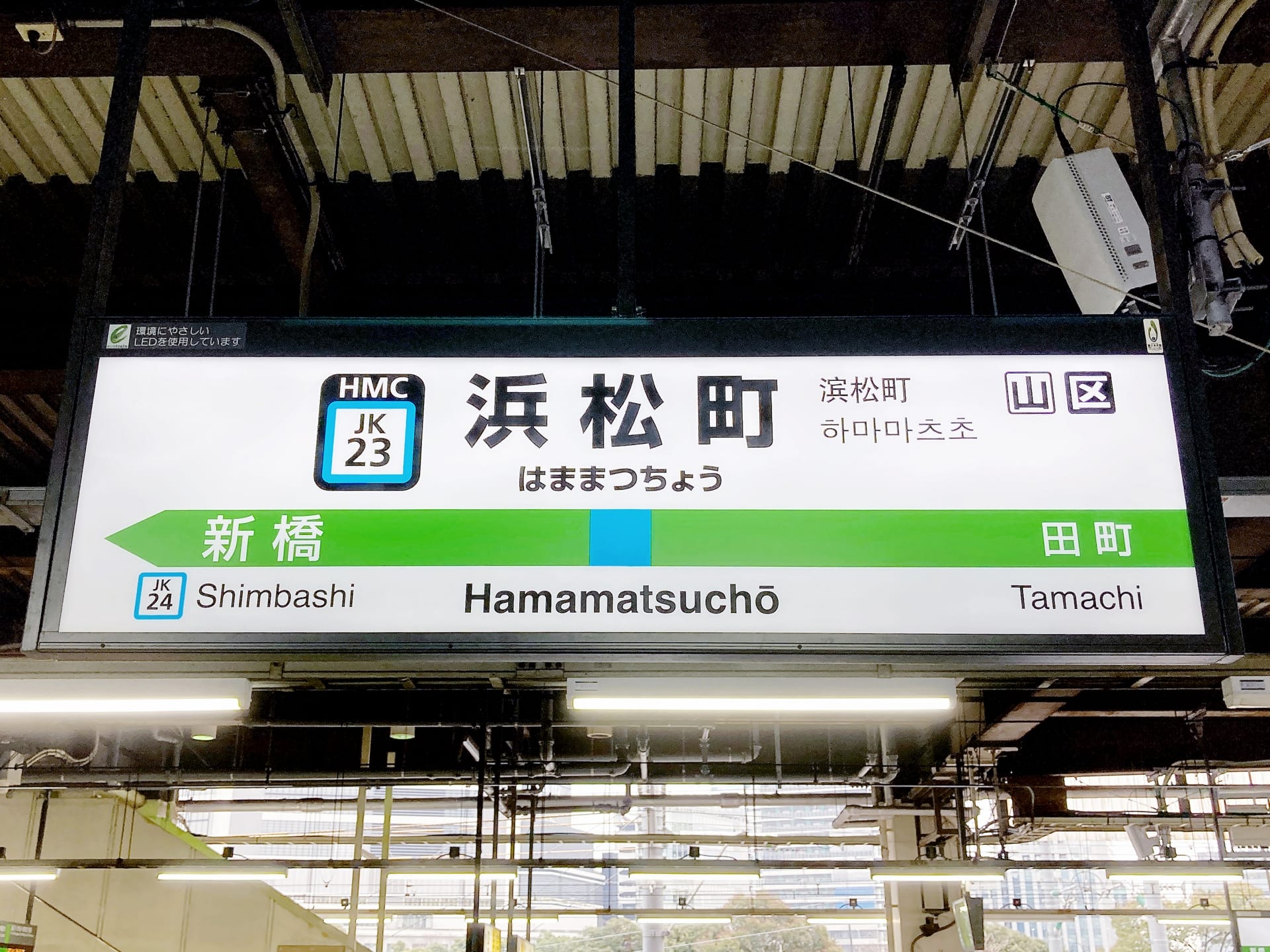 駅名標には「Hamamatsucho」（浜松町）とホームの詳細と近隣の駅名が日本語と英語で誇らしげに表示されています。旅行者に最適で、市の中心部で個別の韓国語レッスンを提供する韓国語教室マンツーマンにも近いです。.