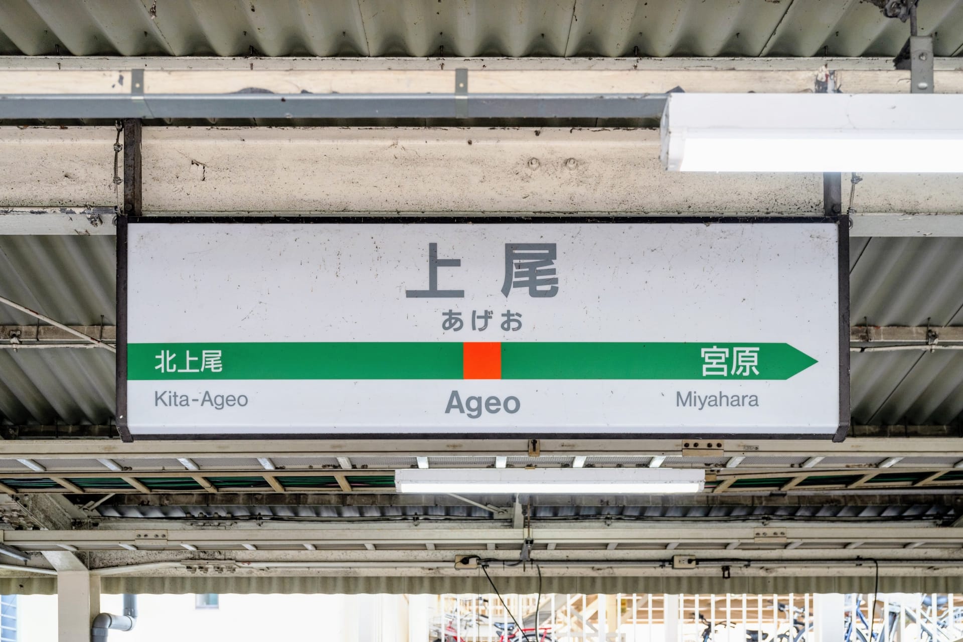 上尾駅の標識は波板屋根の下にあり、左側が北上尾、右側が宮原と日本語とローマ字で案内されています。近くにある上尾では、個人に合わせた韓国語教室マンツーマンのレッスンを受けられます。.