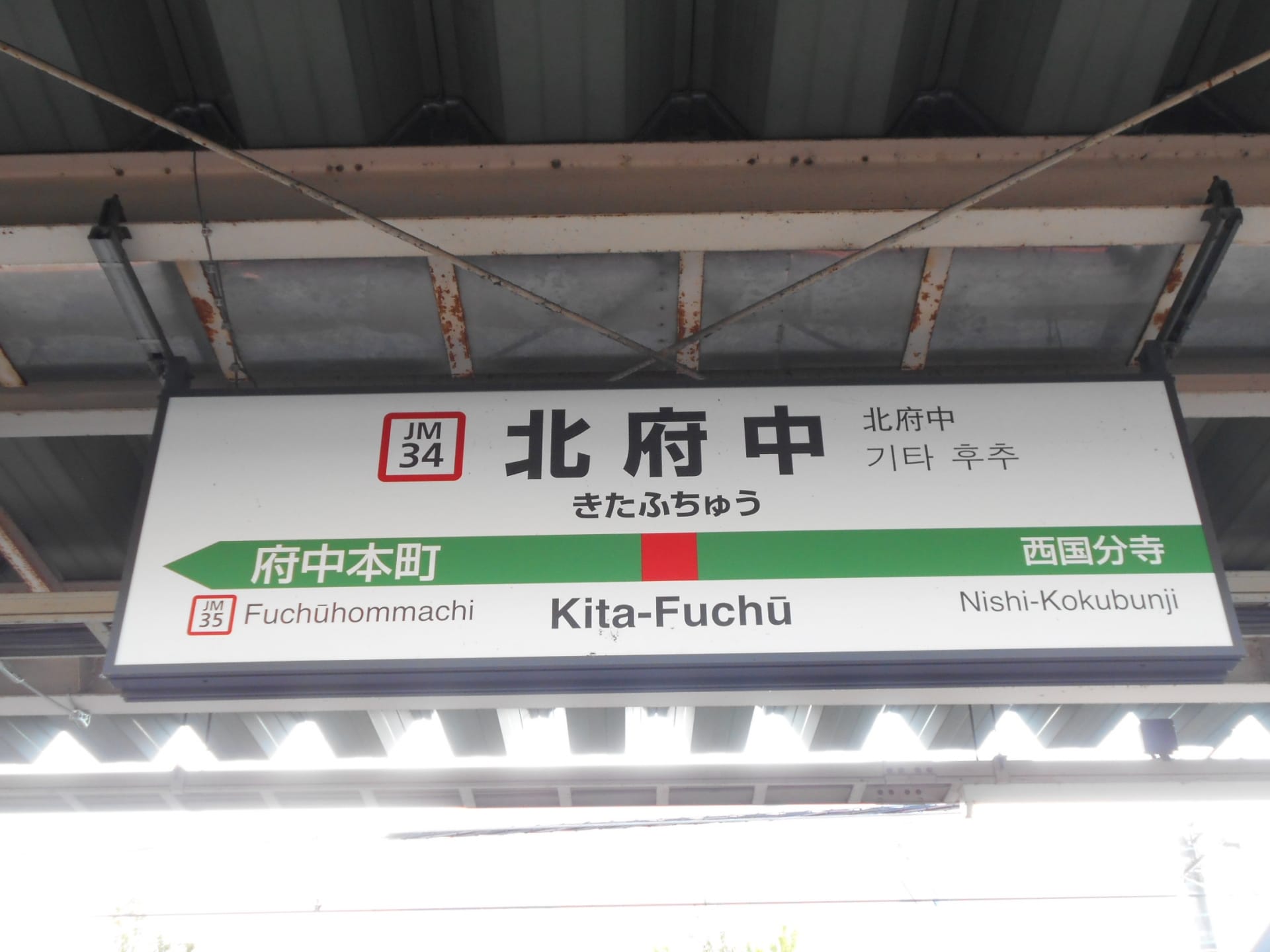 日本の北府中の鉄道駅標識。駅コード JM34 と JM35 で府中本町と西国分寺への接続を表示します。韓国語教室マンマンツーやその他の地元の目的地に向かう生徒に最適です。.