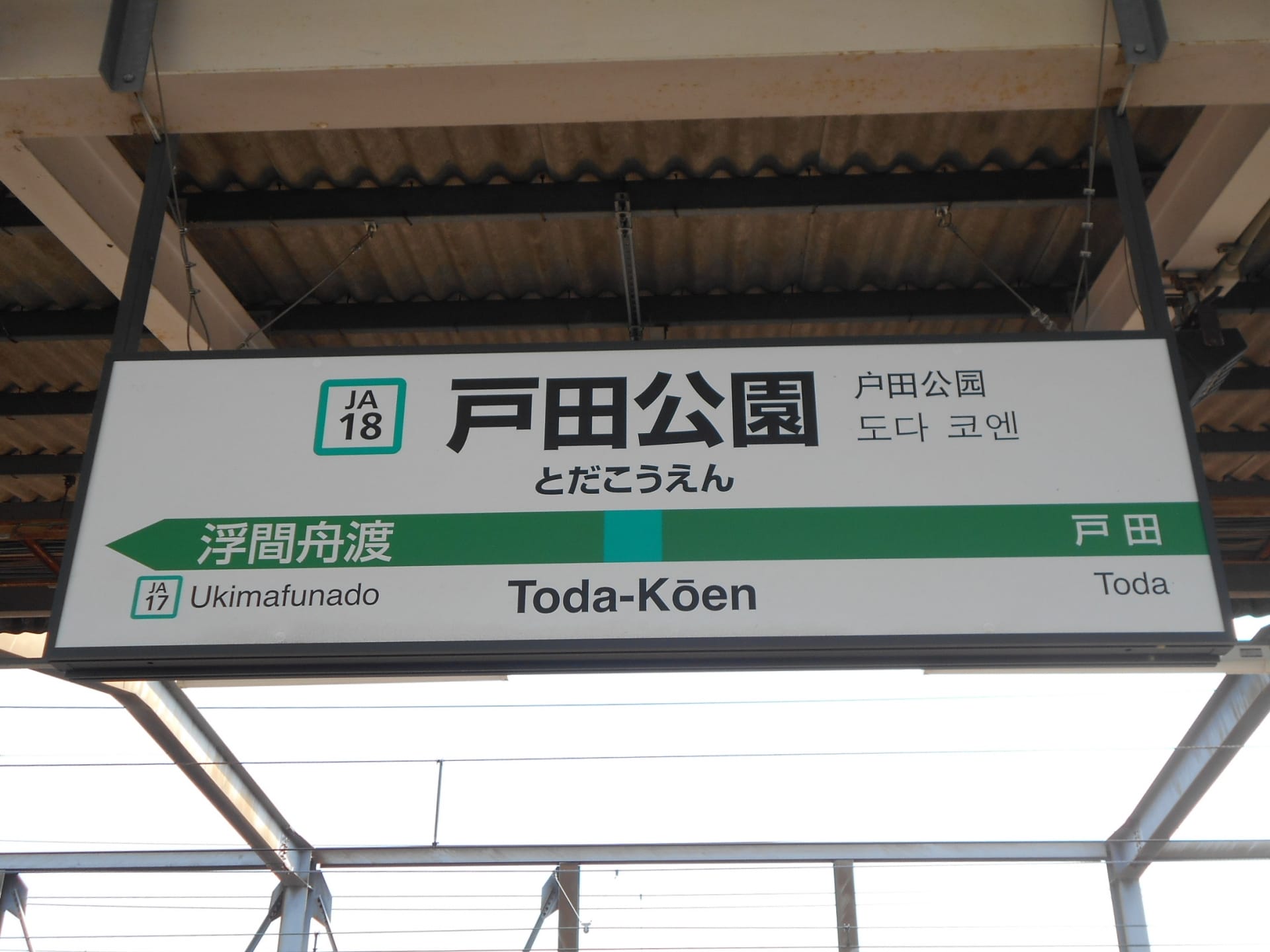 駅ホームの標識には日本語と英語で「戸田公園」と表示され、駅番号JA17浮間船渡とJA18戸田が明記されている。.