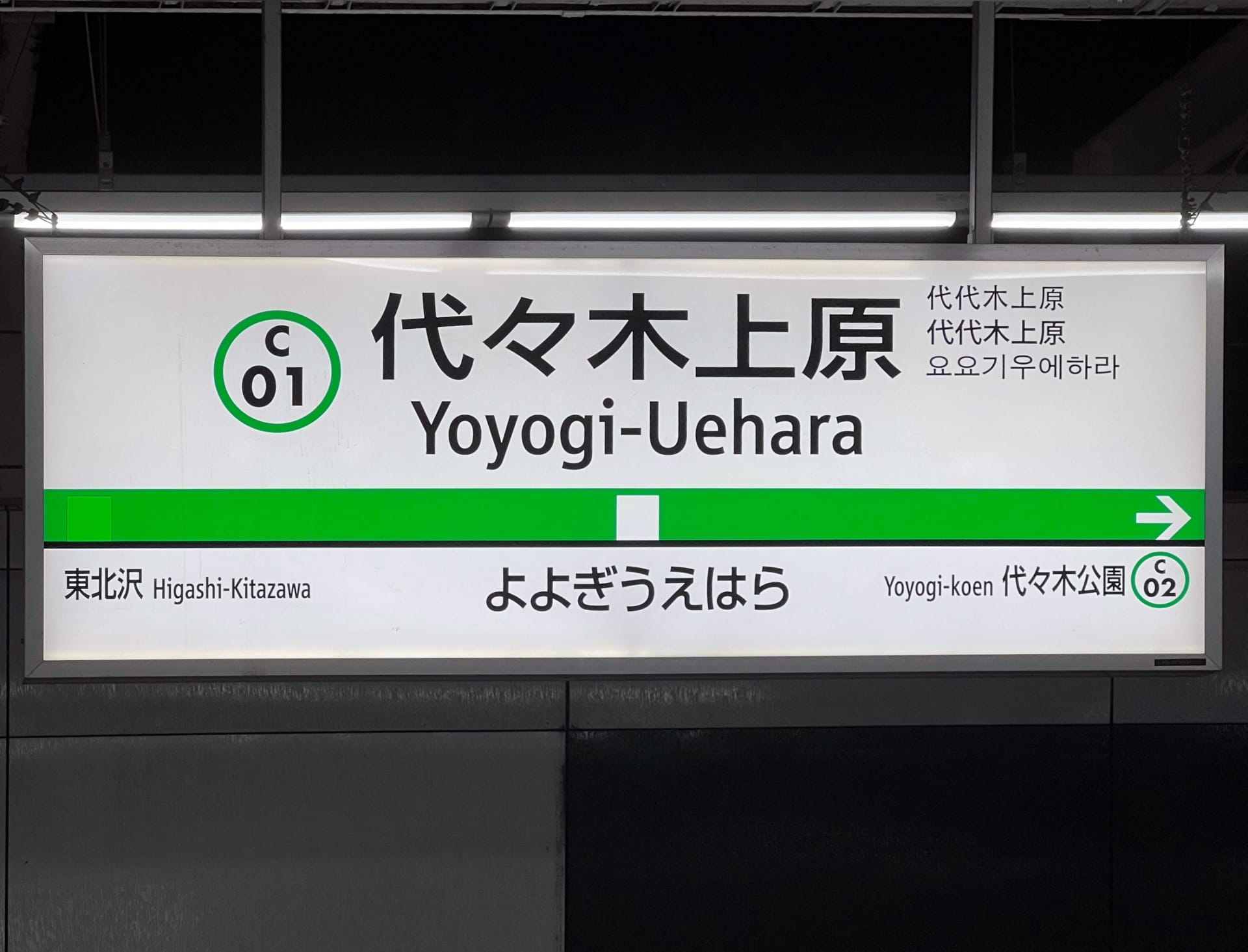 代々木上原方面の地下鉄駅標識。日本語、韓国語、英語で情報が表示され、東北沢方面と代々木公園方面の方向指示器が付いています。韓国語教室マンツーマンの近くに位置し、集中的な学習の機会を提供します。.
