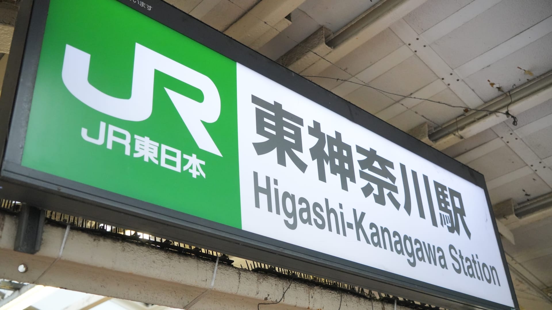JR東日本のロゴが入った東神奈川駅の標識。日本語と英語の文字が表示されている。.
