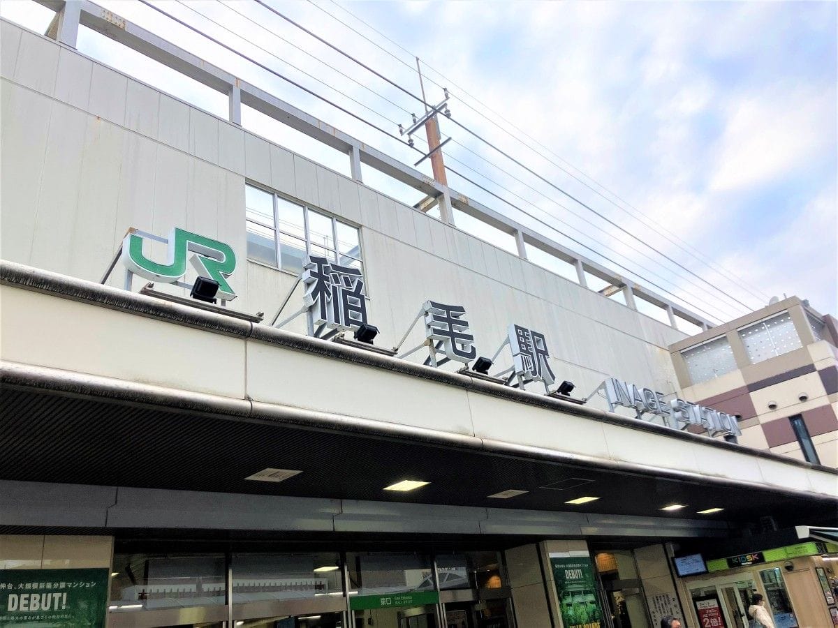 一部曇り空の下、JRのロゴとサイン。.