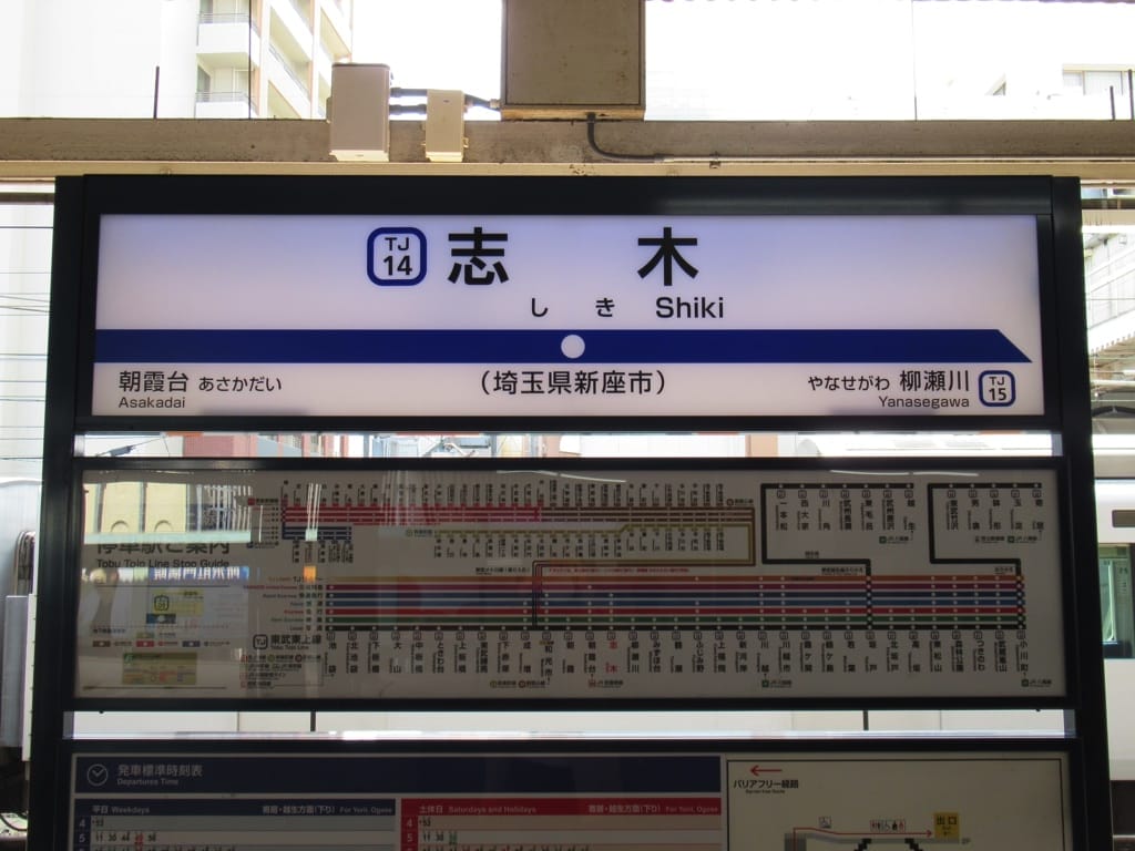 日本語と英語で表記された志木駅の駅名表示板。その下には、ホーム案内と詳細な路線図が掲載されています。.